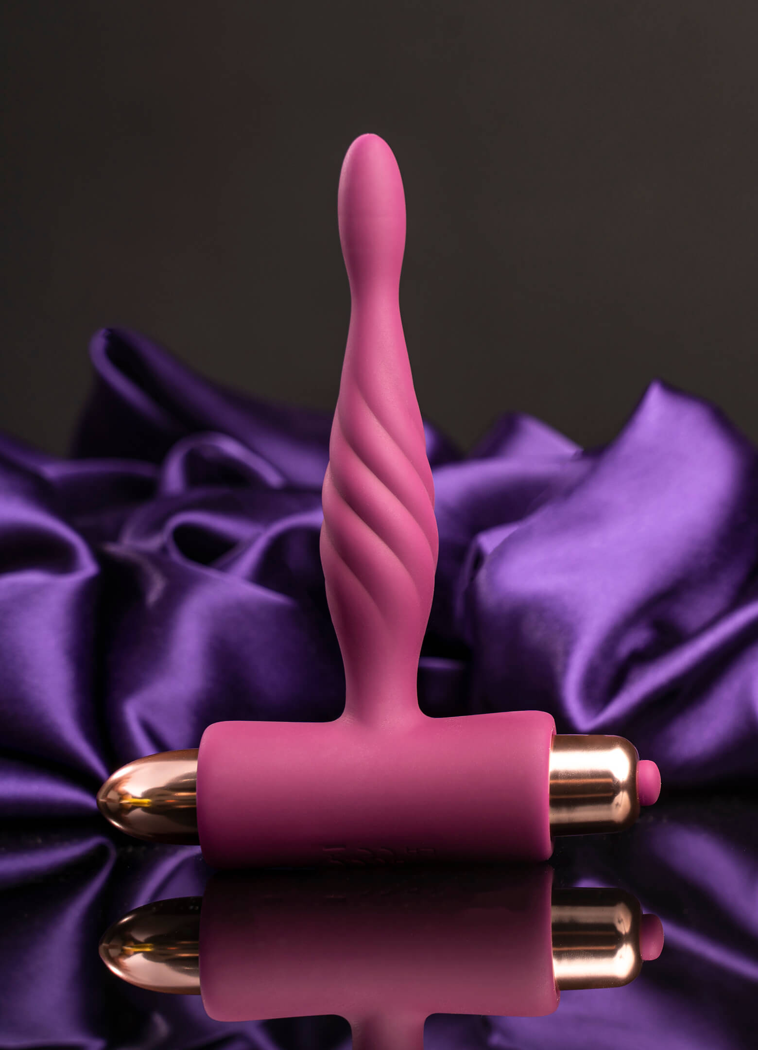 Super slim burgundy butt plug housing a removable rose gold bullet vibrator.