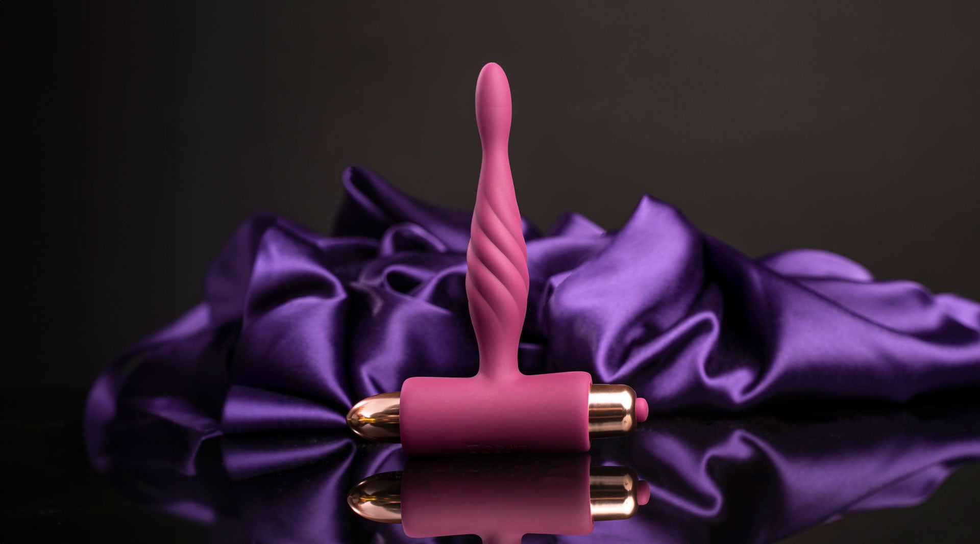 Super slim burgundy butt plug housing a removable rose gold bullet vibrator.