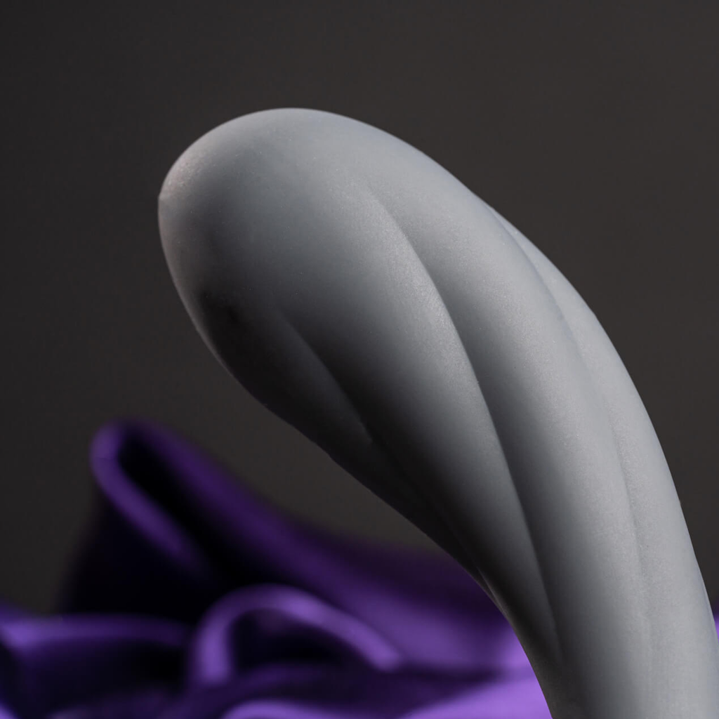 Gray curved handheld massager with smooth surface and subtle ridges