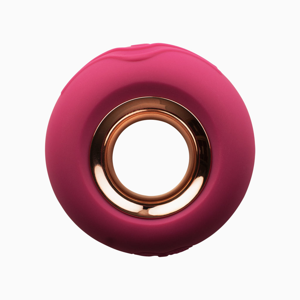 Magenta handheld massager with round copper-toned center ring