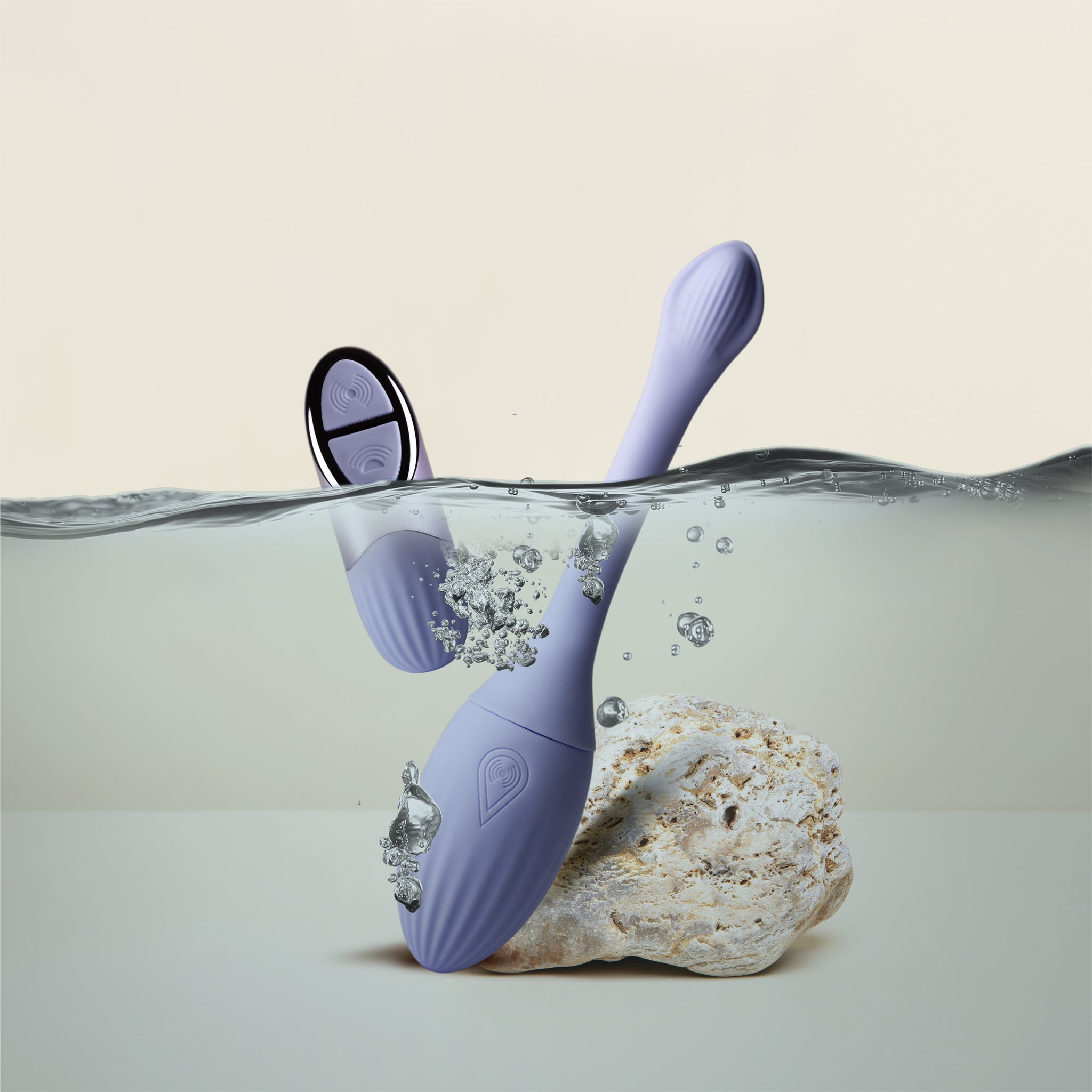 A lavender purple underwater NIYA N1 with a matching remote, partially submerged in water next to a white rock, set against a clean beige background. waterproof design