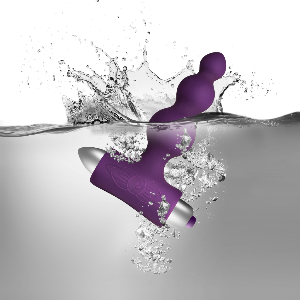 Purple silicone vibrating anal beads with metal base, with water splash around
