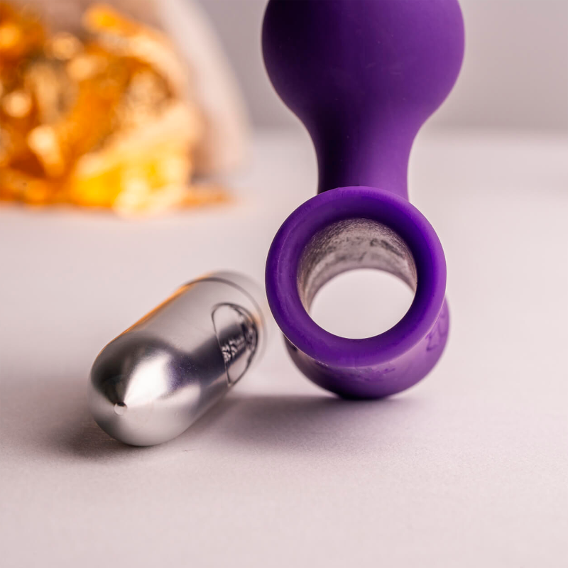 Purple vibrating anal beads close-up with metal end cap and ring-shaped base