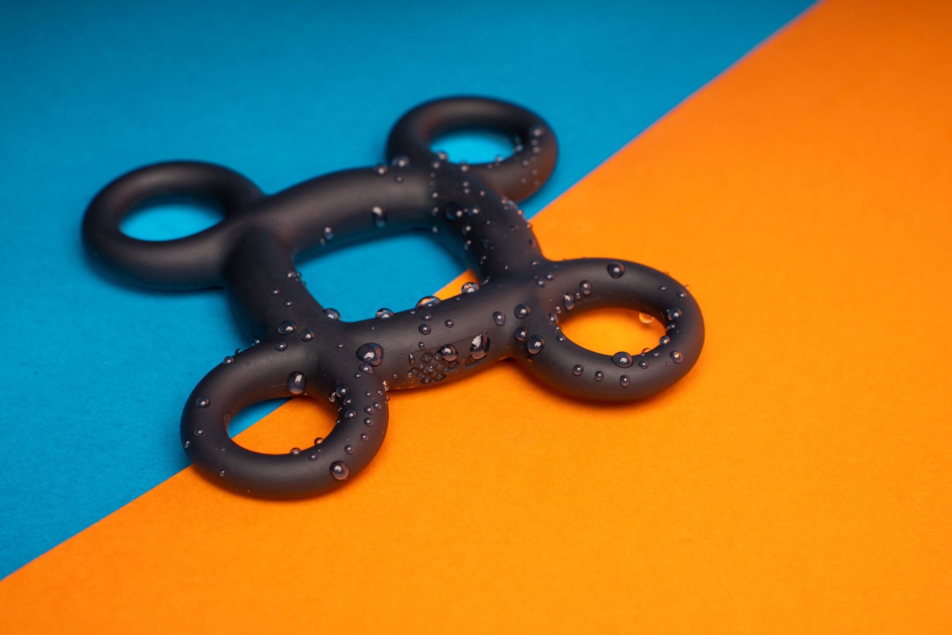 Water droplets showing waterproof accessible cock ring in black.