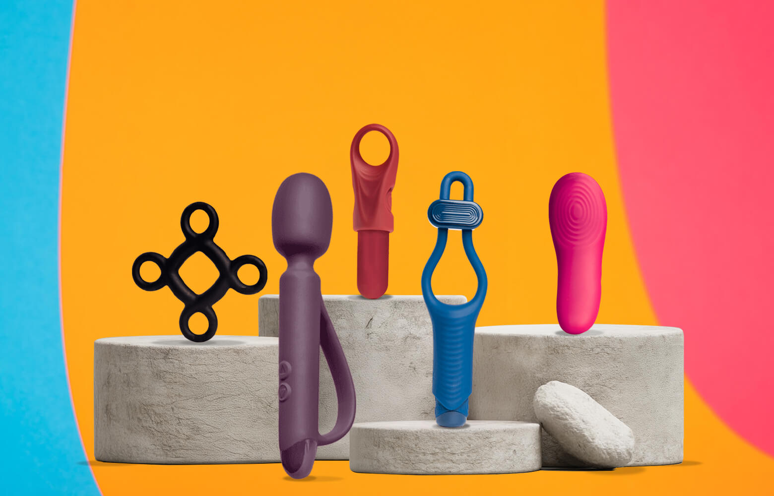Collection of quest products on a stone podium including a wand, c-ring and finger vibrator with a bright colourful background