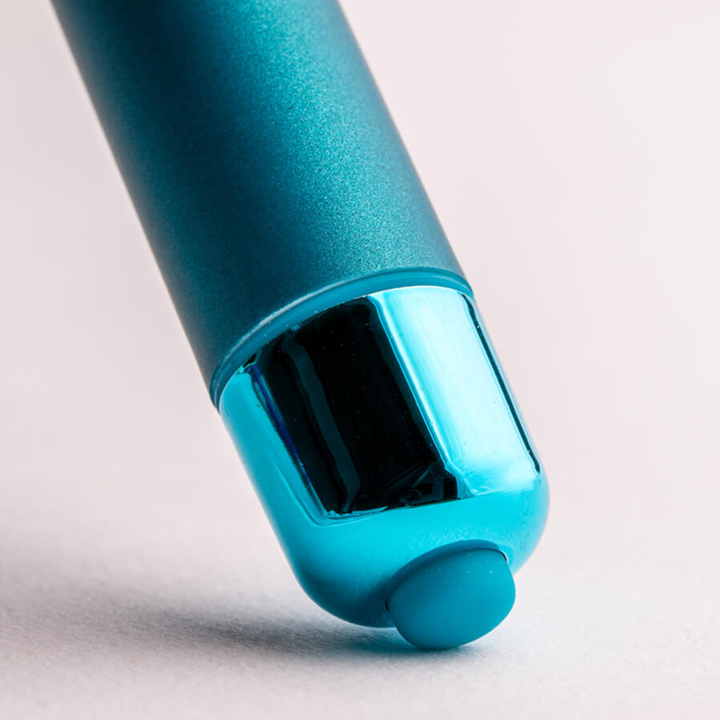 Teal bullet vibrator tip detail with dark window and light end cap