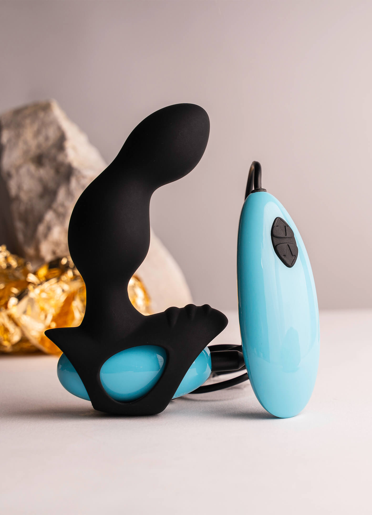 Remote controlled prostate vibrator in black and blue with a ribbed perineum pleasure point.