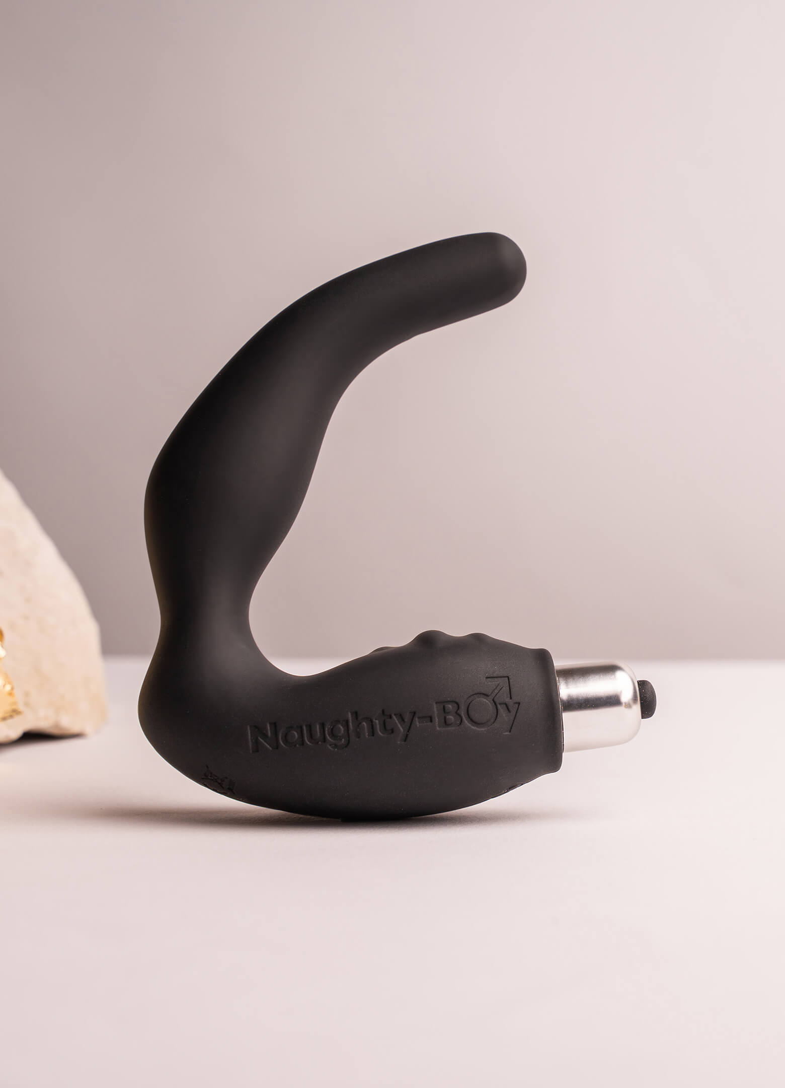 Silicone prostate massager with rippled perineum pleasure points housing a removable bullet vibrator in black.