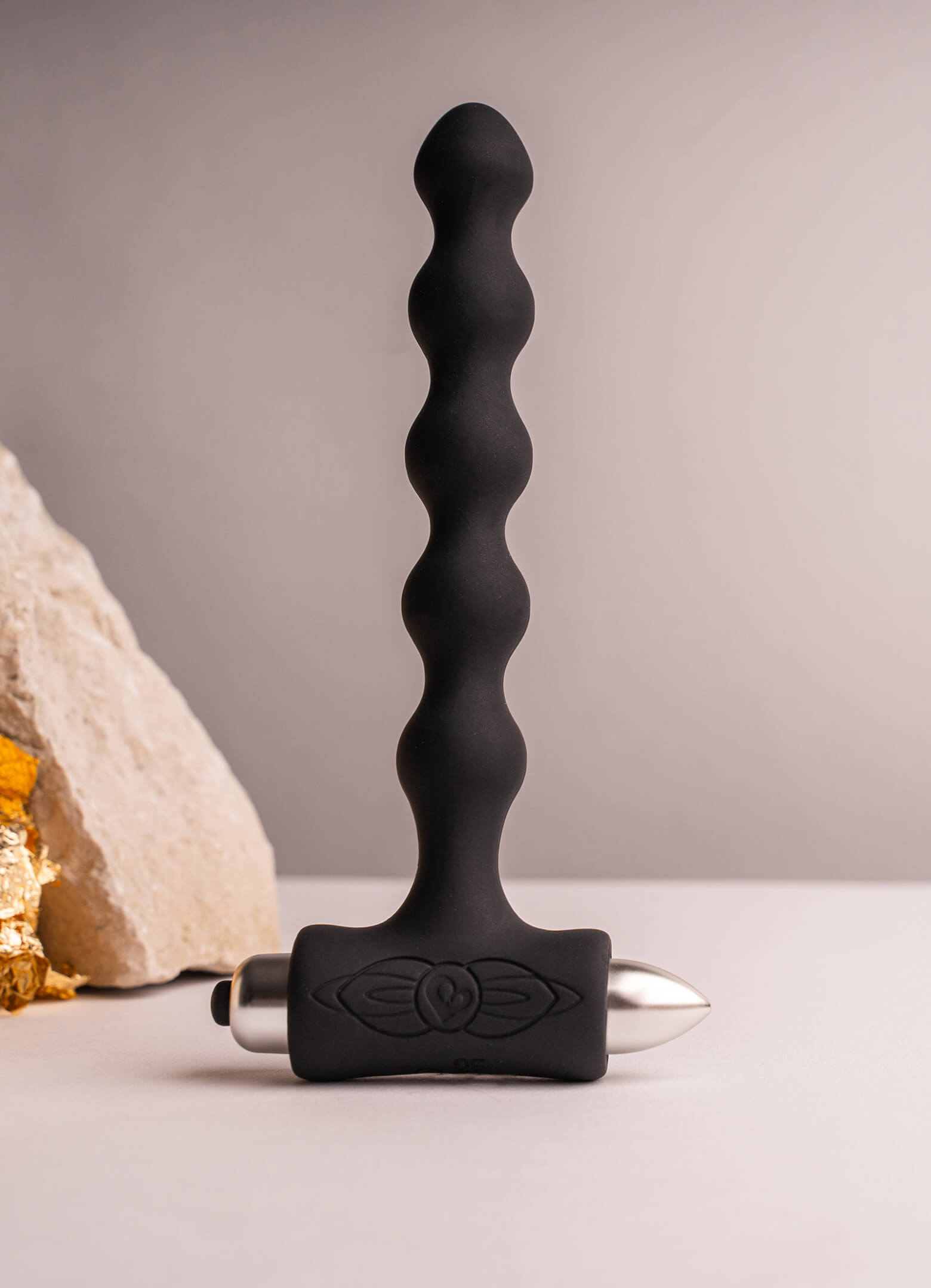 Beaded silicone butt plug in black housing a removable bullet vibrator.
