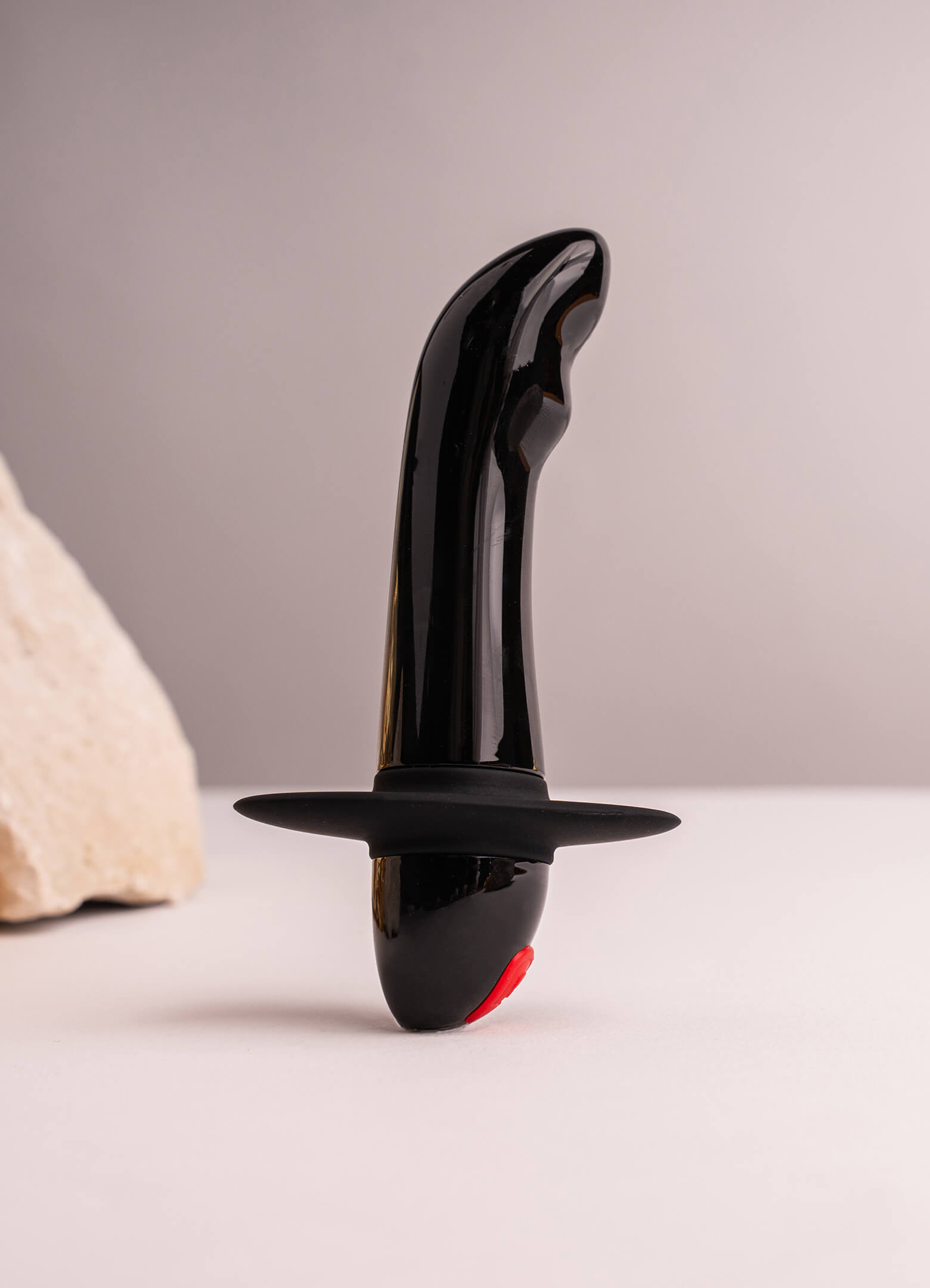 Small black prostate vibrator with a safety flange.