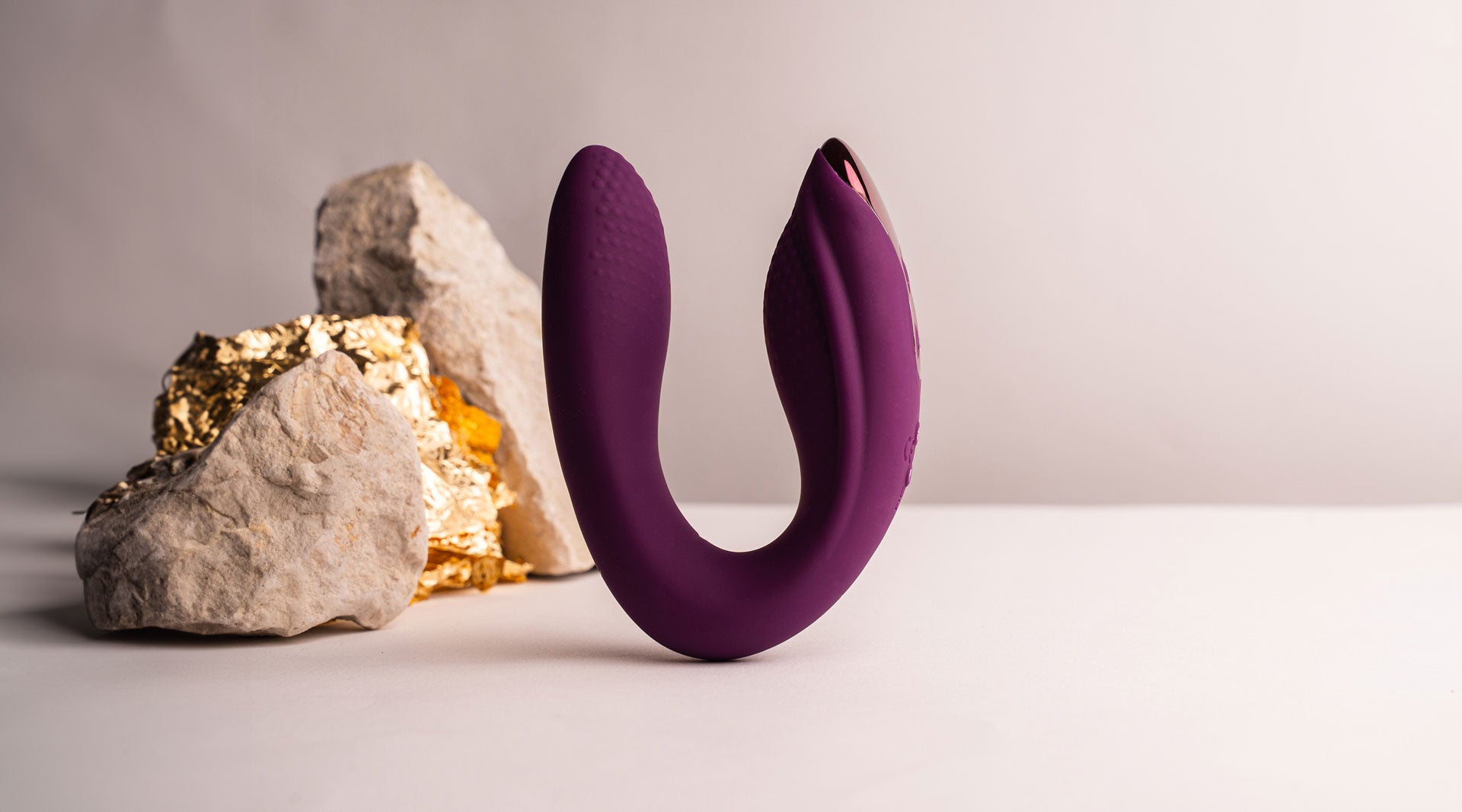 Burgundy silicone C-shaped internal and external vibrator.