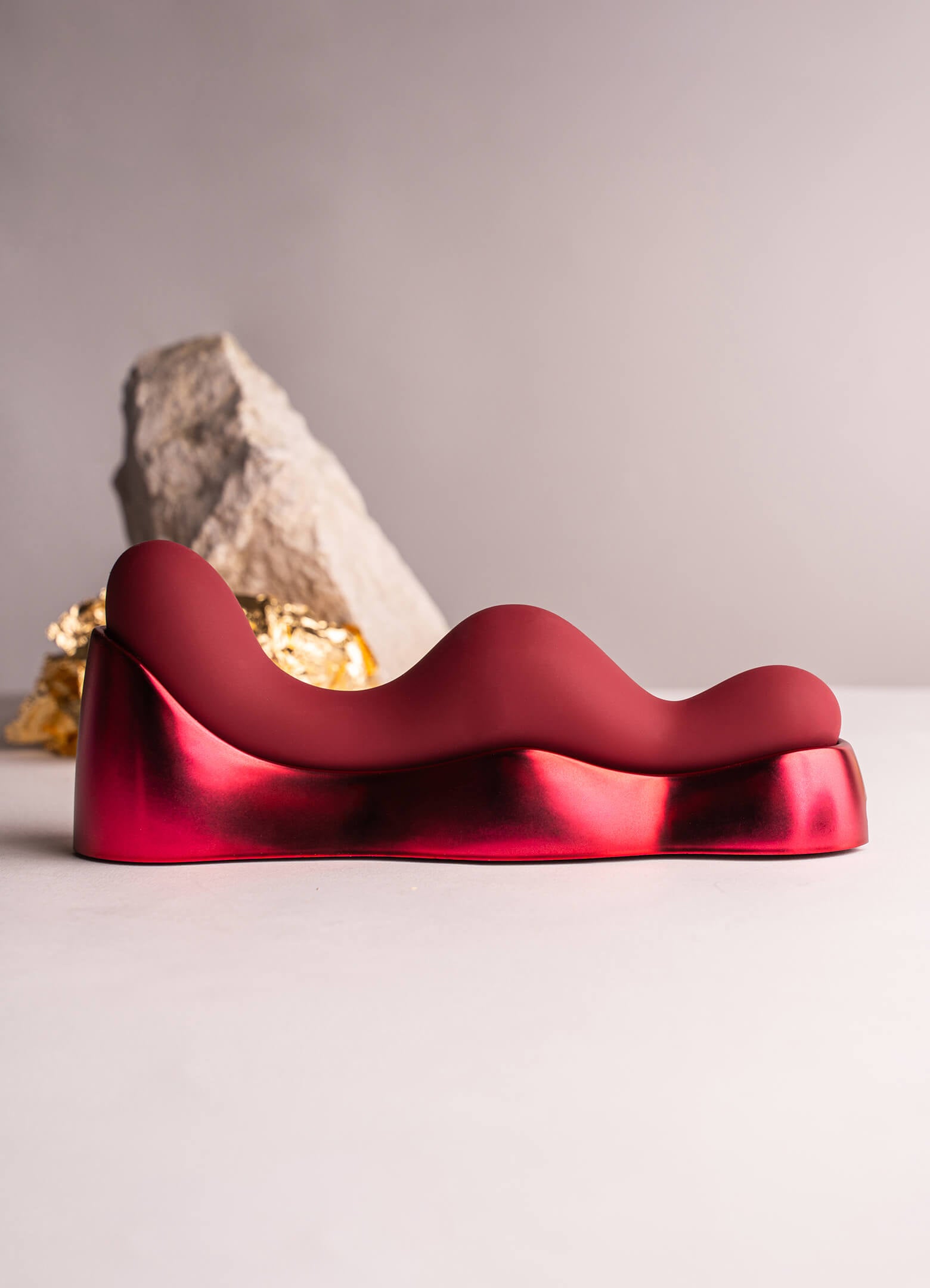 Silicone sit on grind on G-spot vibrator with charging unit in red.