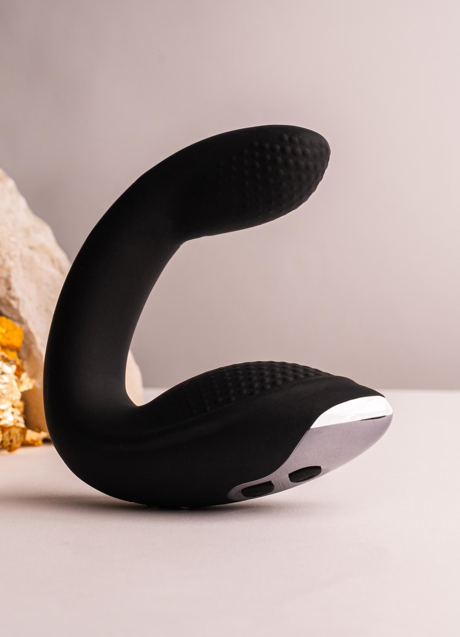 Vibrating C-shaped remote prostate massager with perineum stimulation base in black.