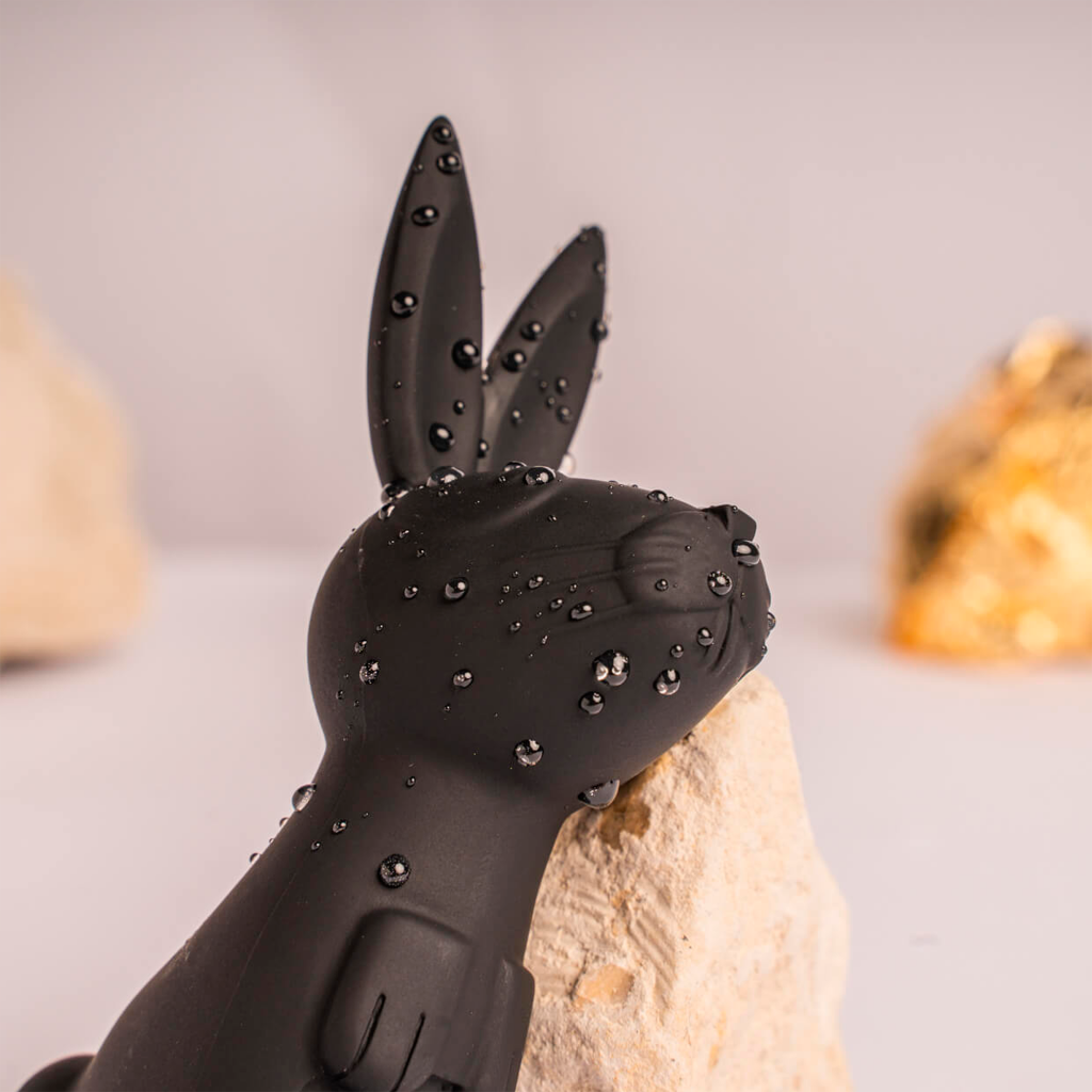 Black bunny-shaped silicone massager with studded bumps and two upright ears