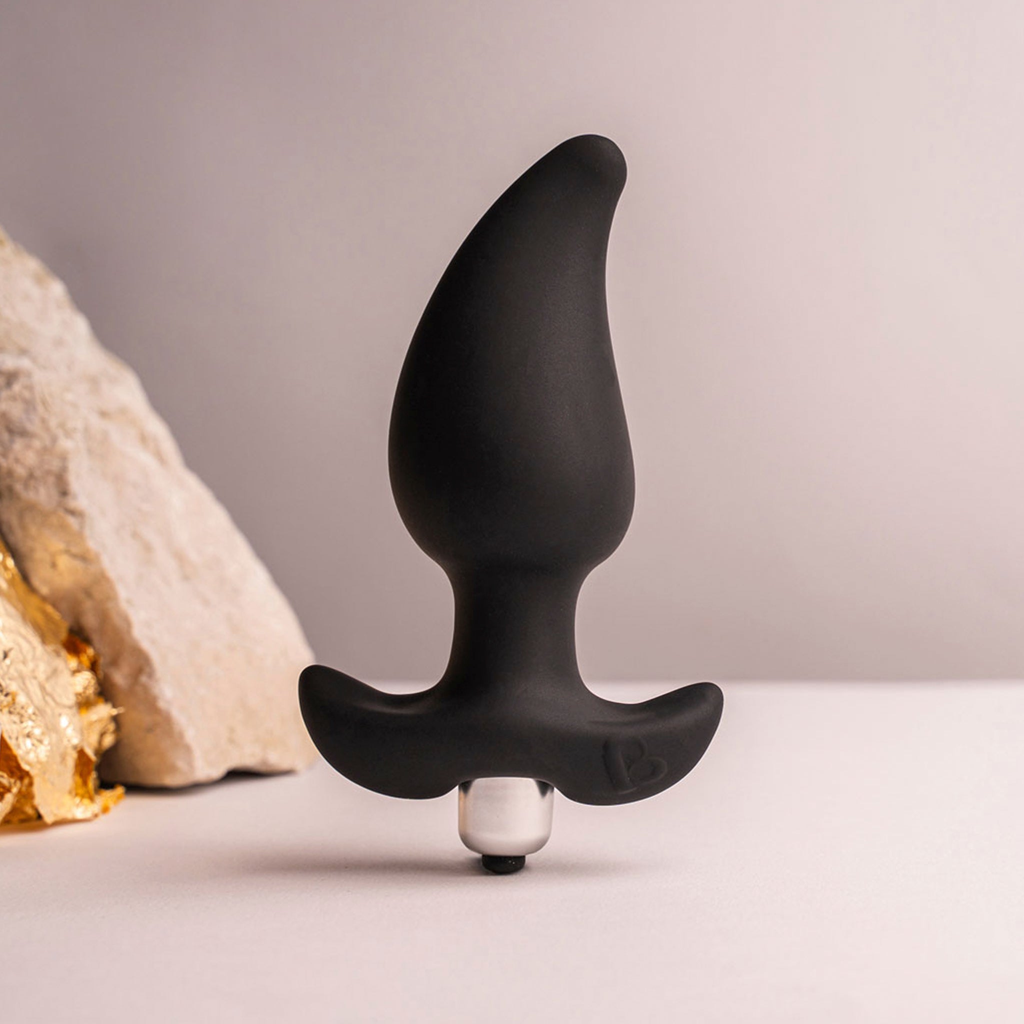 Rocks Off Butt Quiver - Black Butt Plug With Bullet Vibe - lifestyle shot with tactical rock
