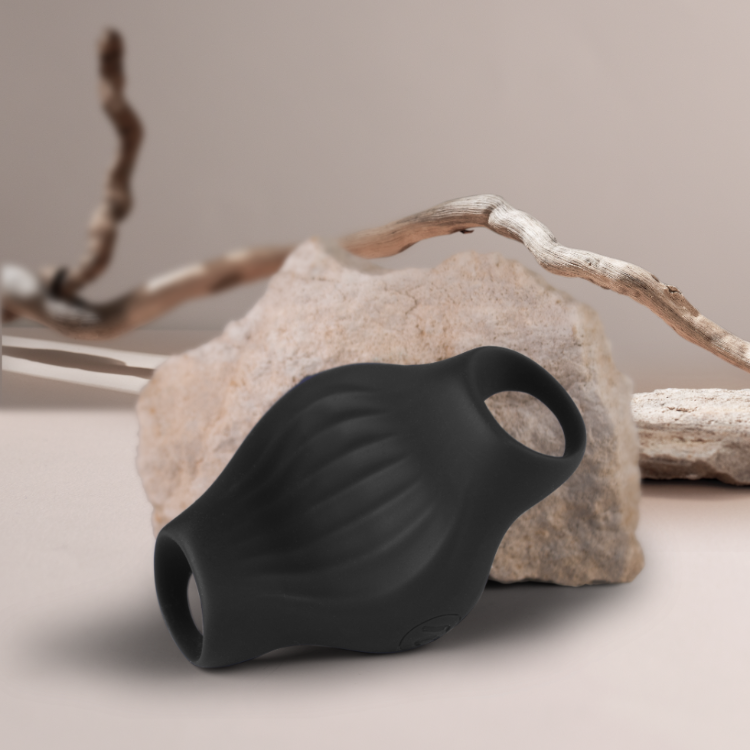 Black flexible silicone device with two loop openings, angled front close-up