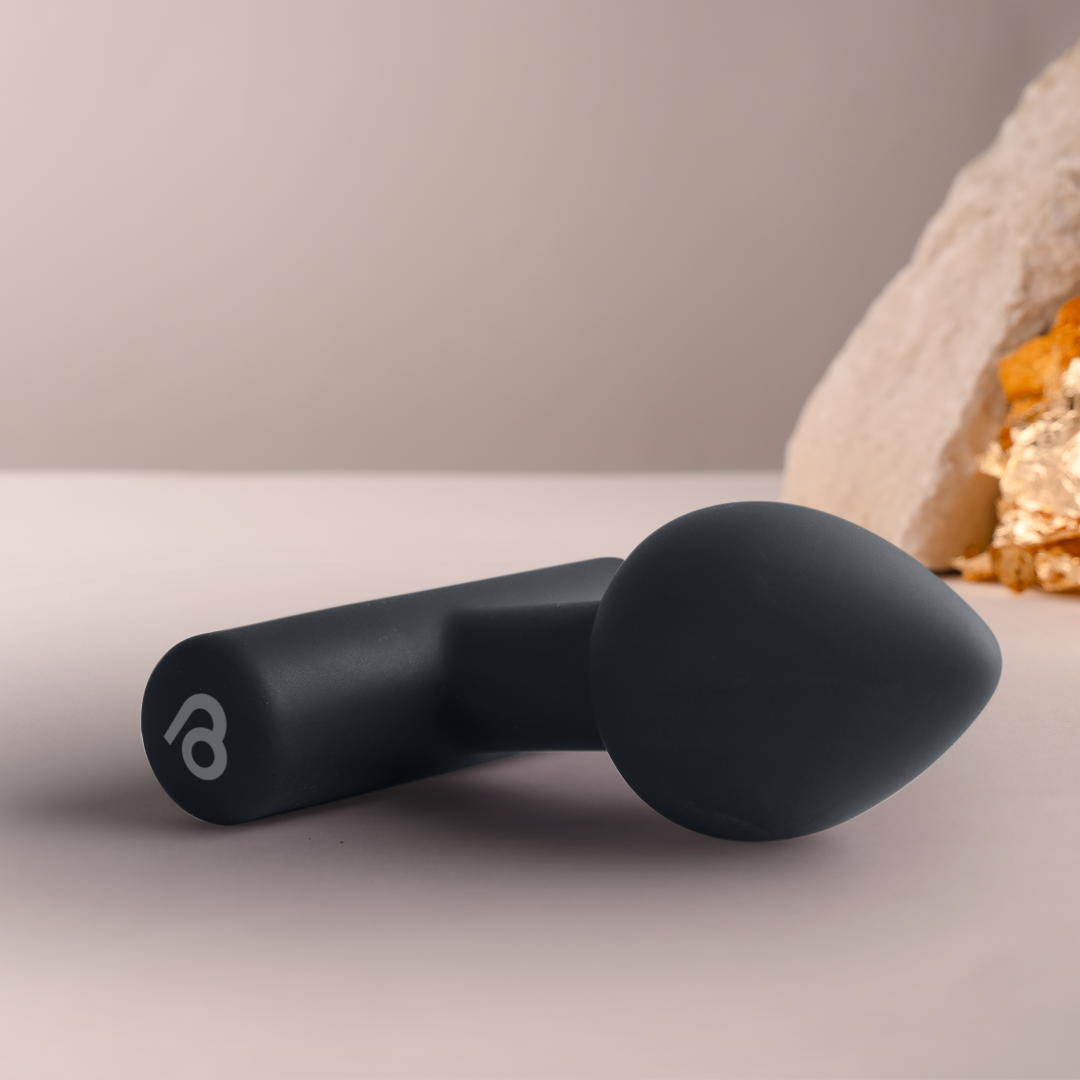 Black silicone plug with rounded tip and flared base, side charging port visible.