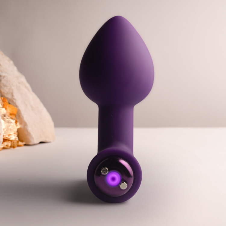 Purple silicone plug standing upright, tapered tip with flared base and circular port