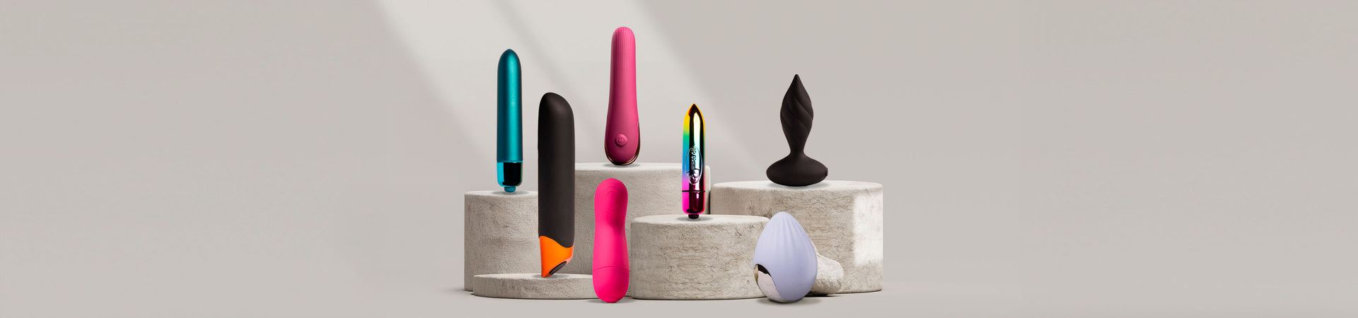 Collection of various vibrating products on a stone podium including bullets 