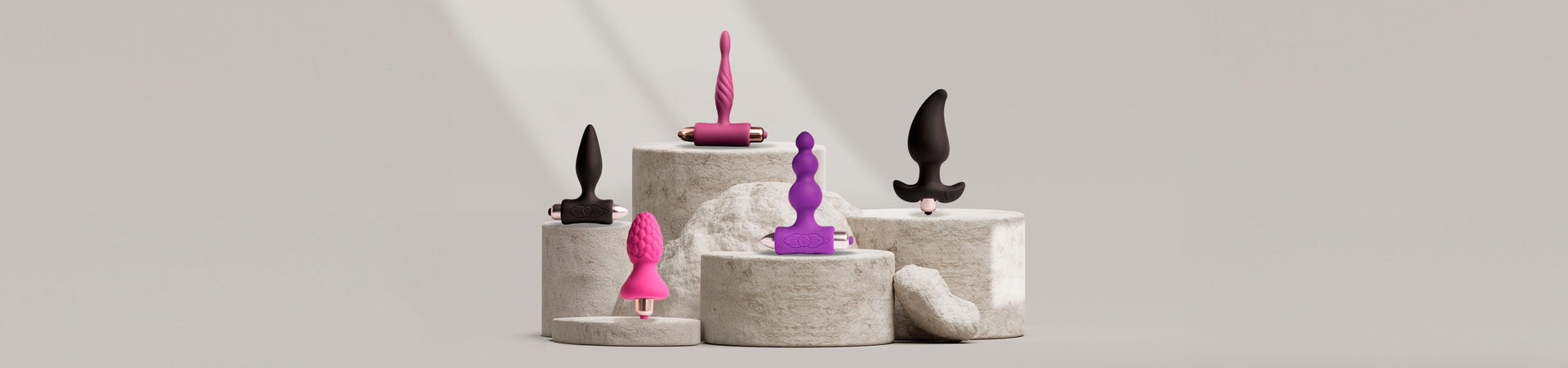 Collection of various sized butt plugs on a stone podium including various shapes