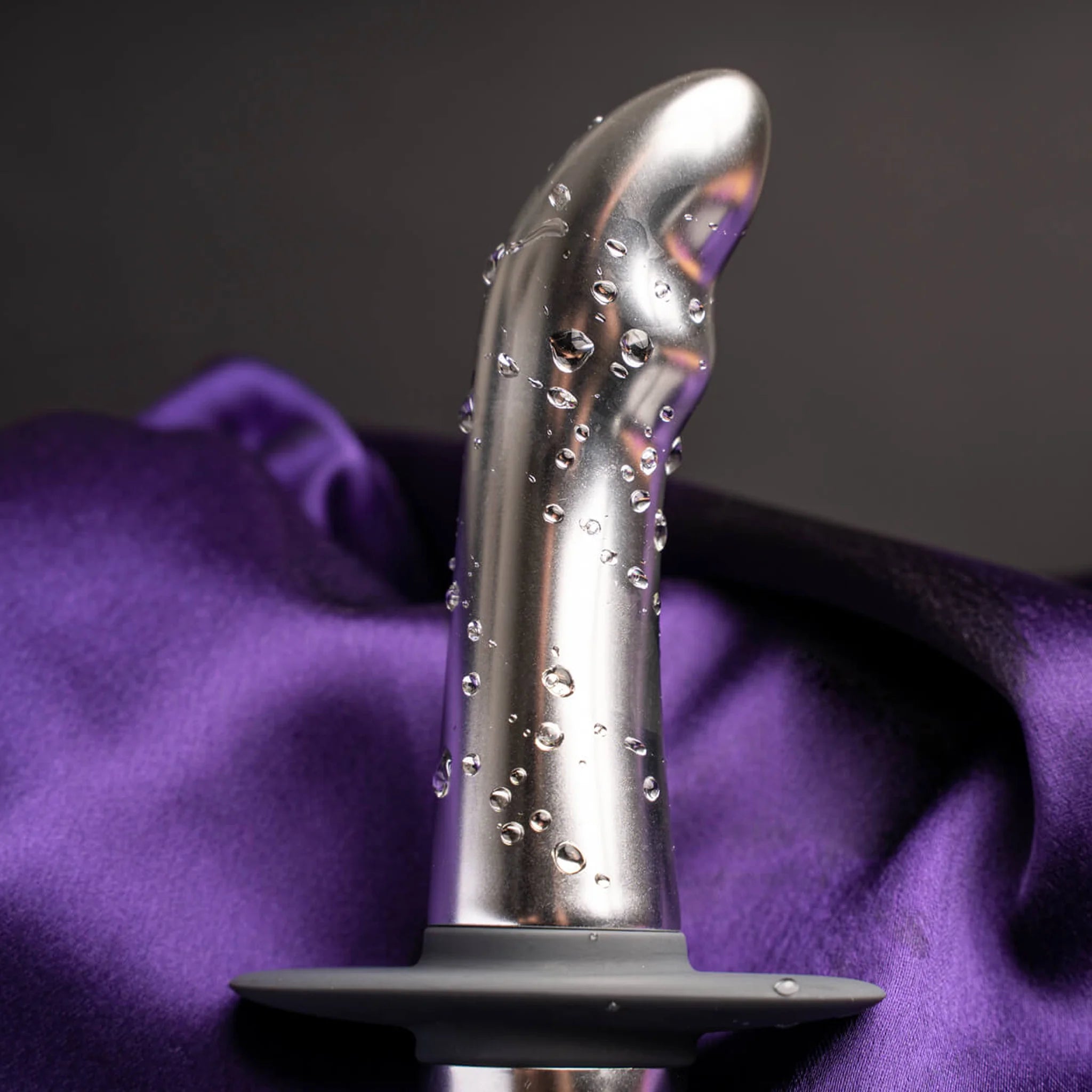 Metallic plug close-up with bubbles on glossy dark gray shaft and base disc