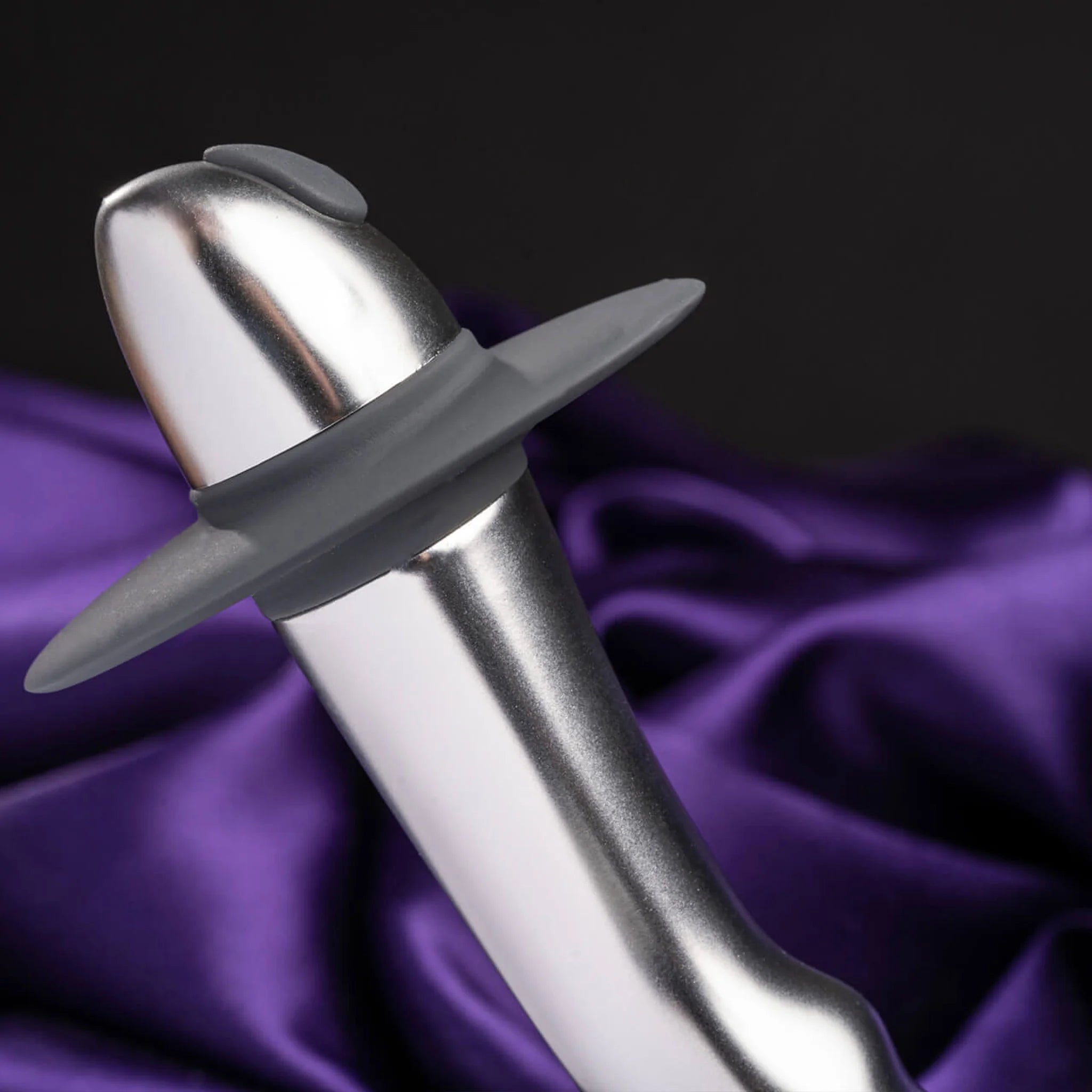 Metallic plug with flared tip and wide base, side angle on purple fabric