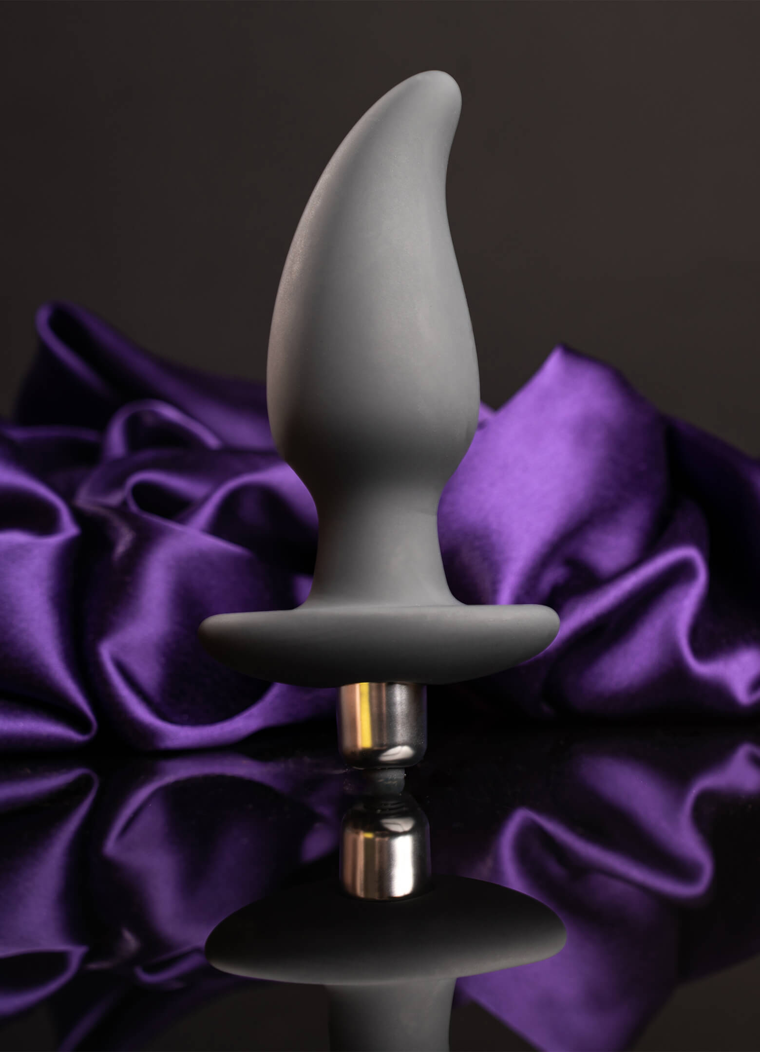 Grey pear shaped butt plug housing a removable bullet vibrator.