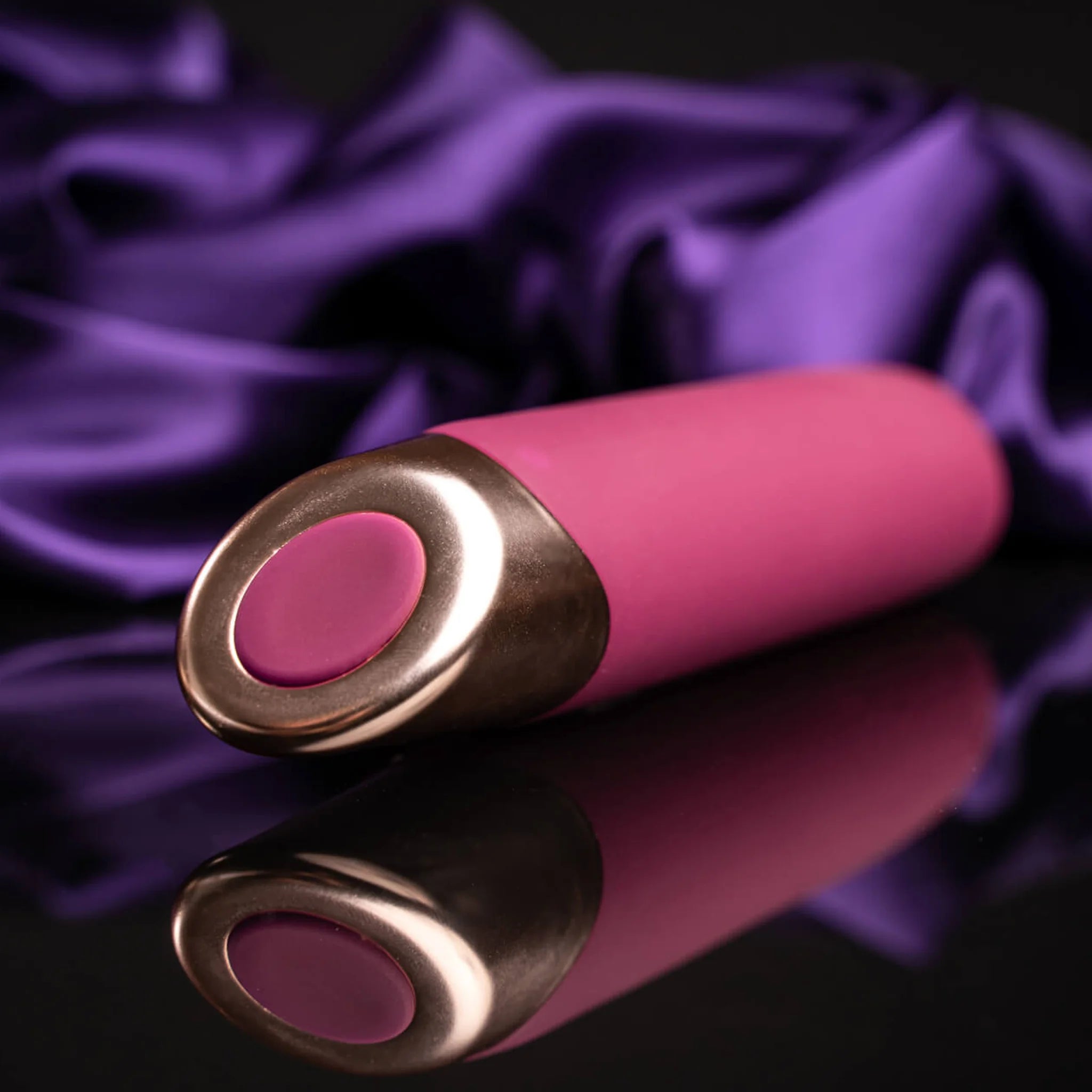 Two-tone vibrator wand: pink-magenta body with metallic circular base ends.