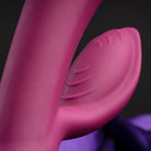Close-up of bright pink rabbit-style massager with ridged silicone tip