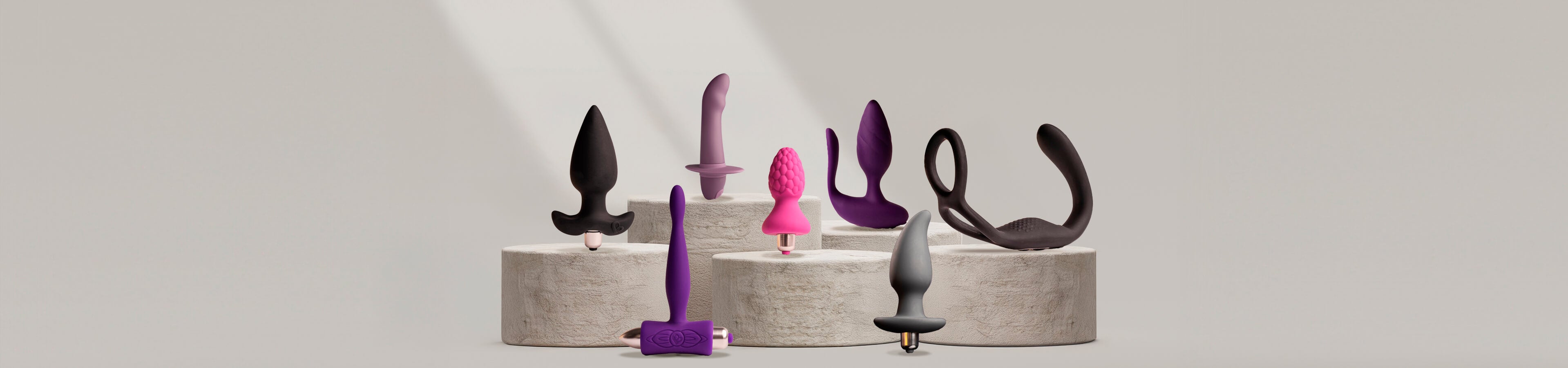 anal products and vibrators on a stone podium and grey background