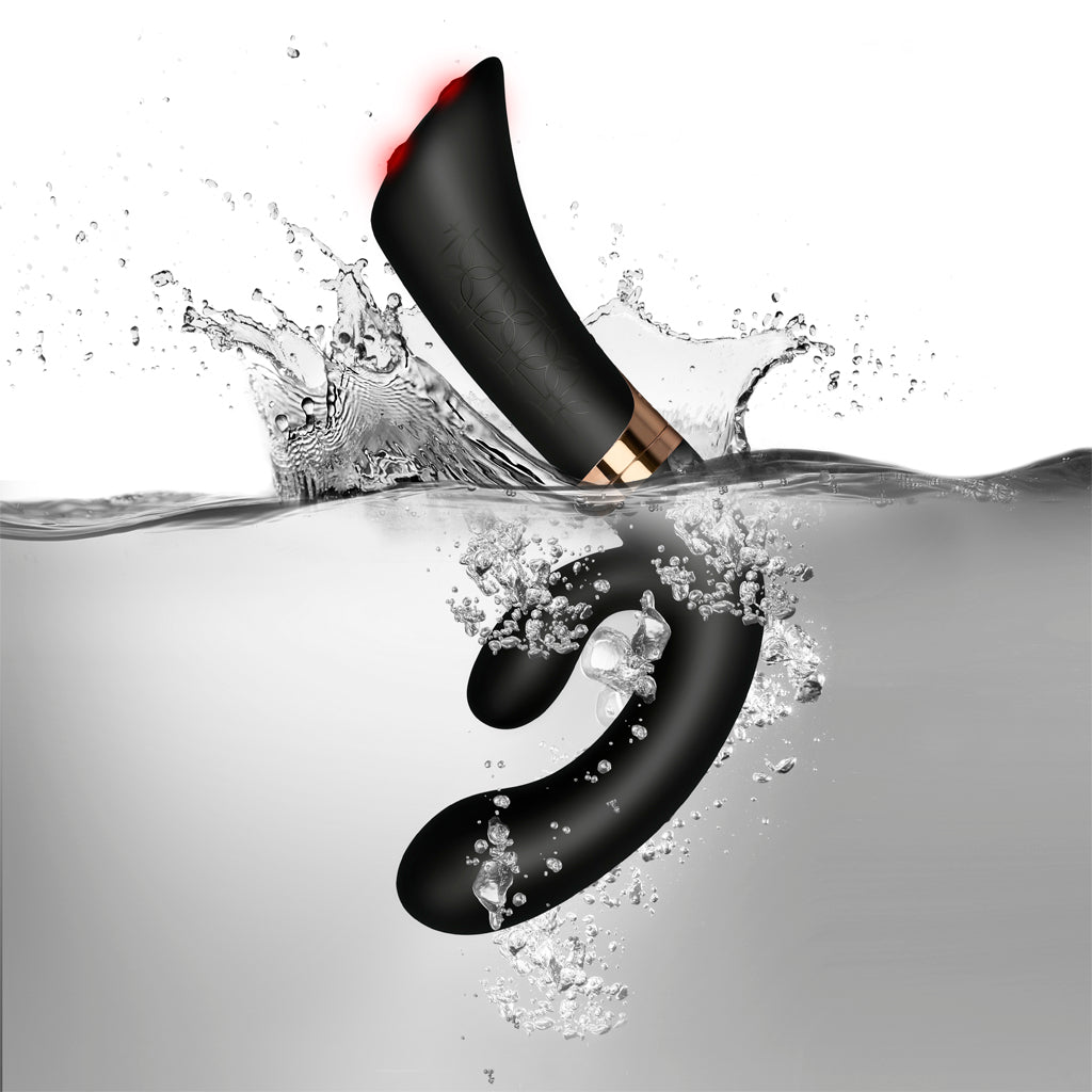 Waterproof FUZION Enigma vibrator partially submerged in clear water spray