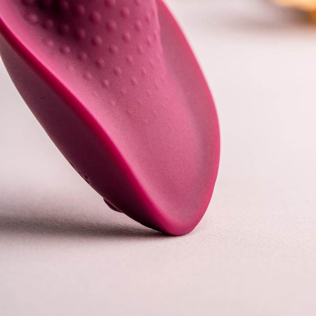 Maroon silicone teardrop massager side profile with dot texture