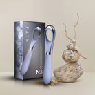 Blue Niya Finger Vibe with packaging and decorative stones on a neutral background
