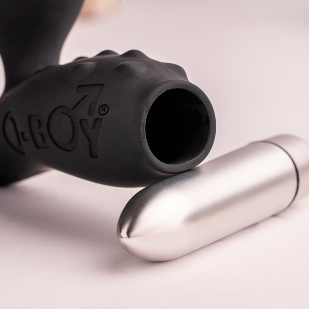 Black silicone anal plug close-up with embossed logo and silver metal insert