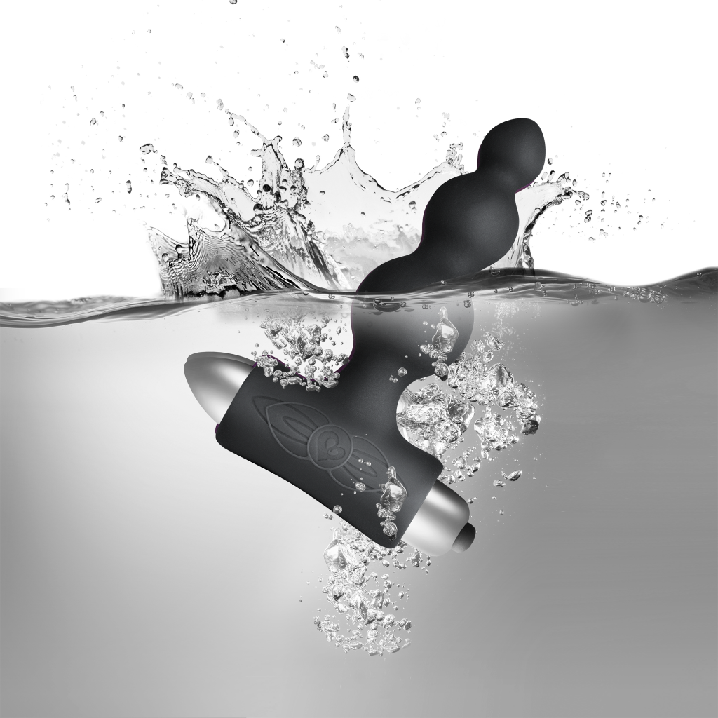 Black silicone vibrating anal beads with metal base, surrounded by water splash