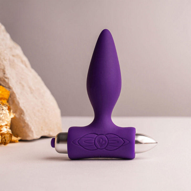 Purple silicone anal plug with sculpted floral emblem and silver handle