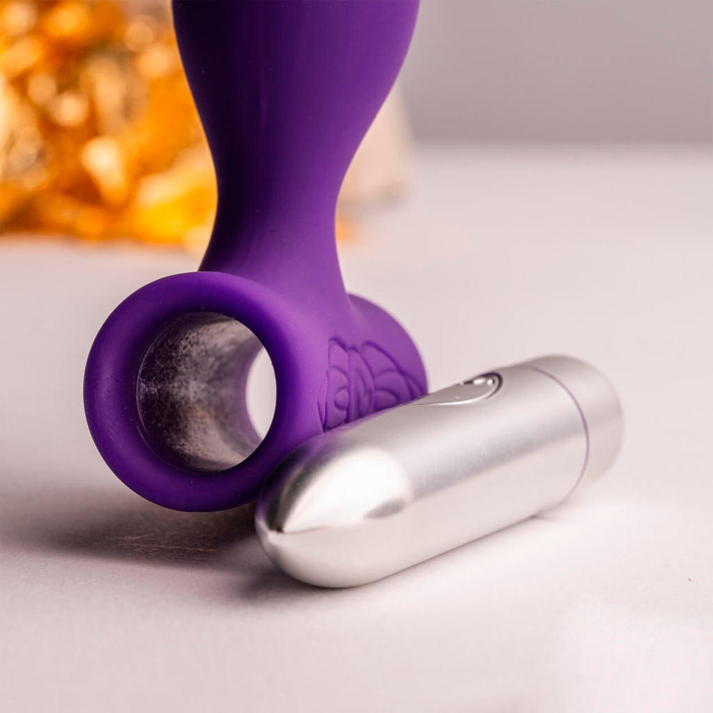 Purple silicone anal plug with round loop base and silver vibrator attachment