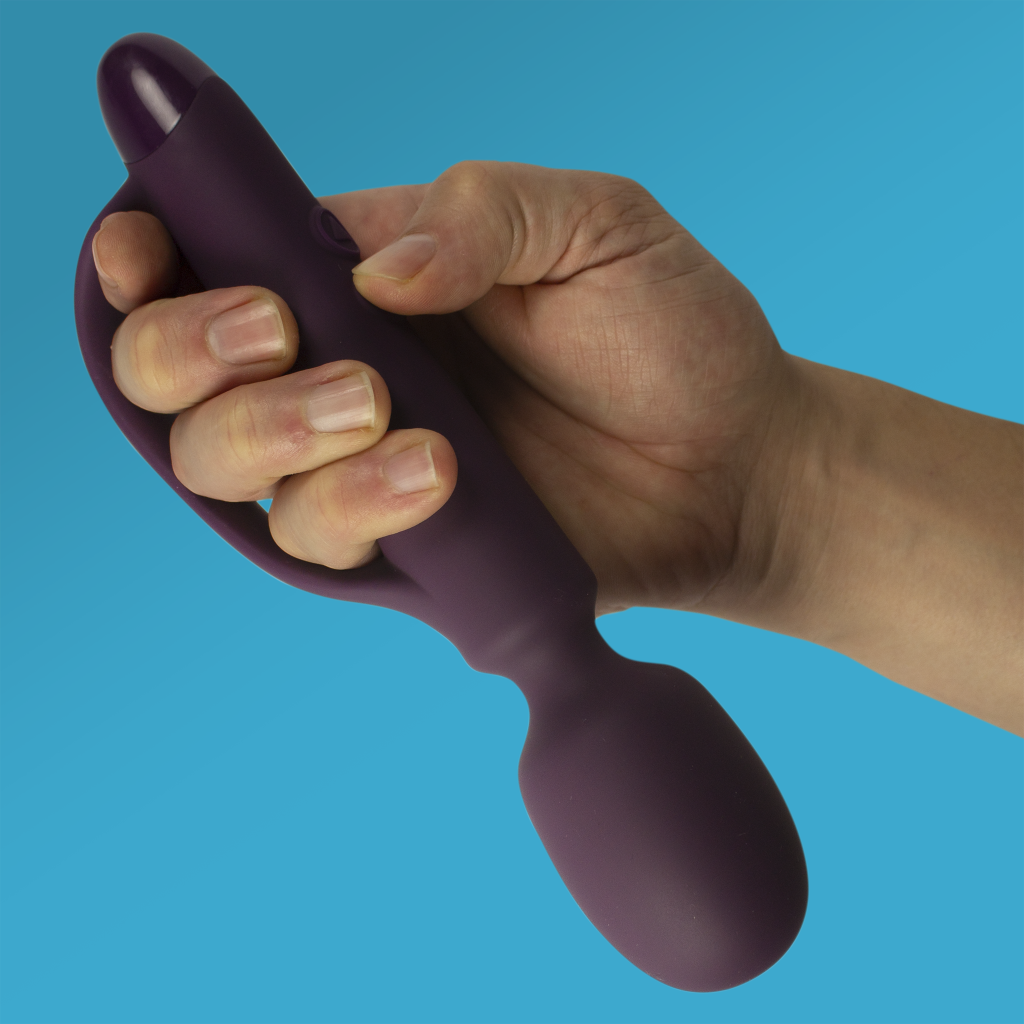 Dark purple silicone wand massager attachment with rounded ends, held in hand