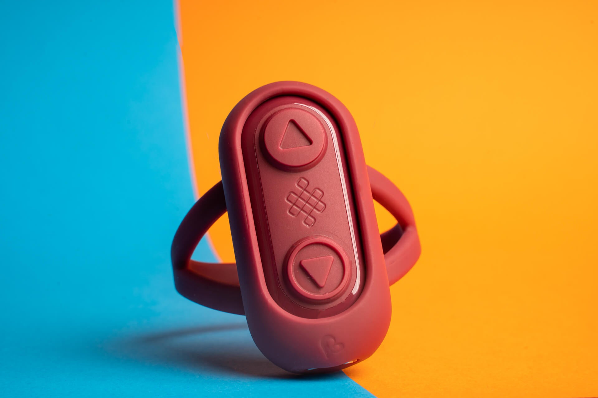 Dark red remote inside a wrist trap with two large buttons.