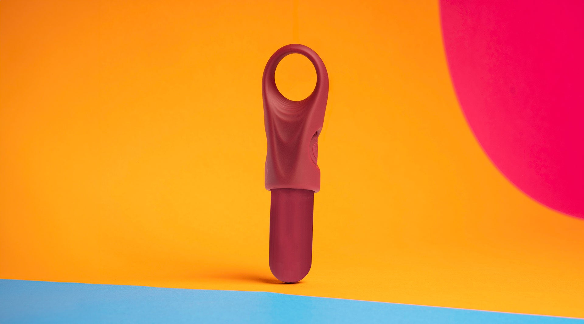 Ergonomic and accessible finger vibrator in burgundy housing a removable bullet vibrator.