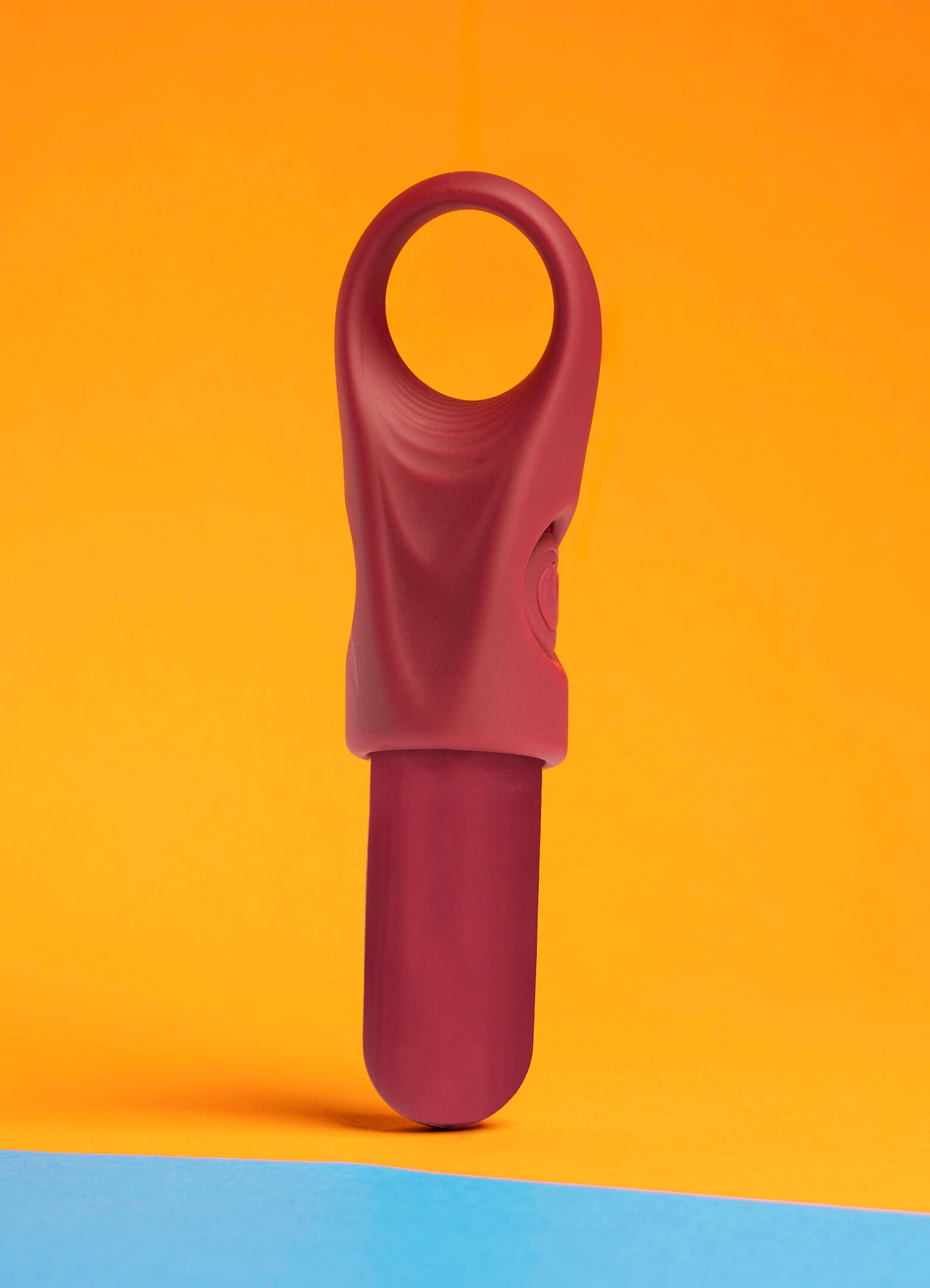 Ergonomic and accessible finger vibrator in burgundy housing a removable bullet vibrator.