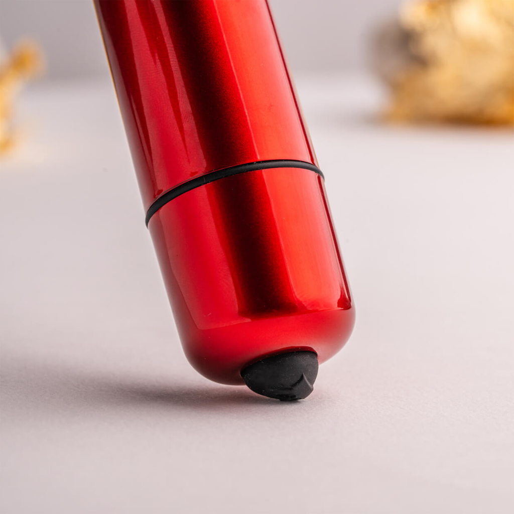 Red bullet-shaped device with black base cap and smooth glossy finish