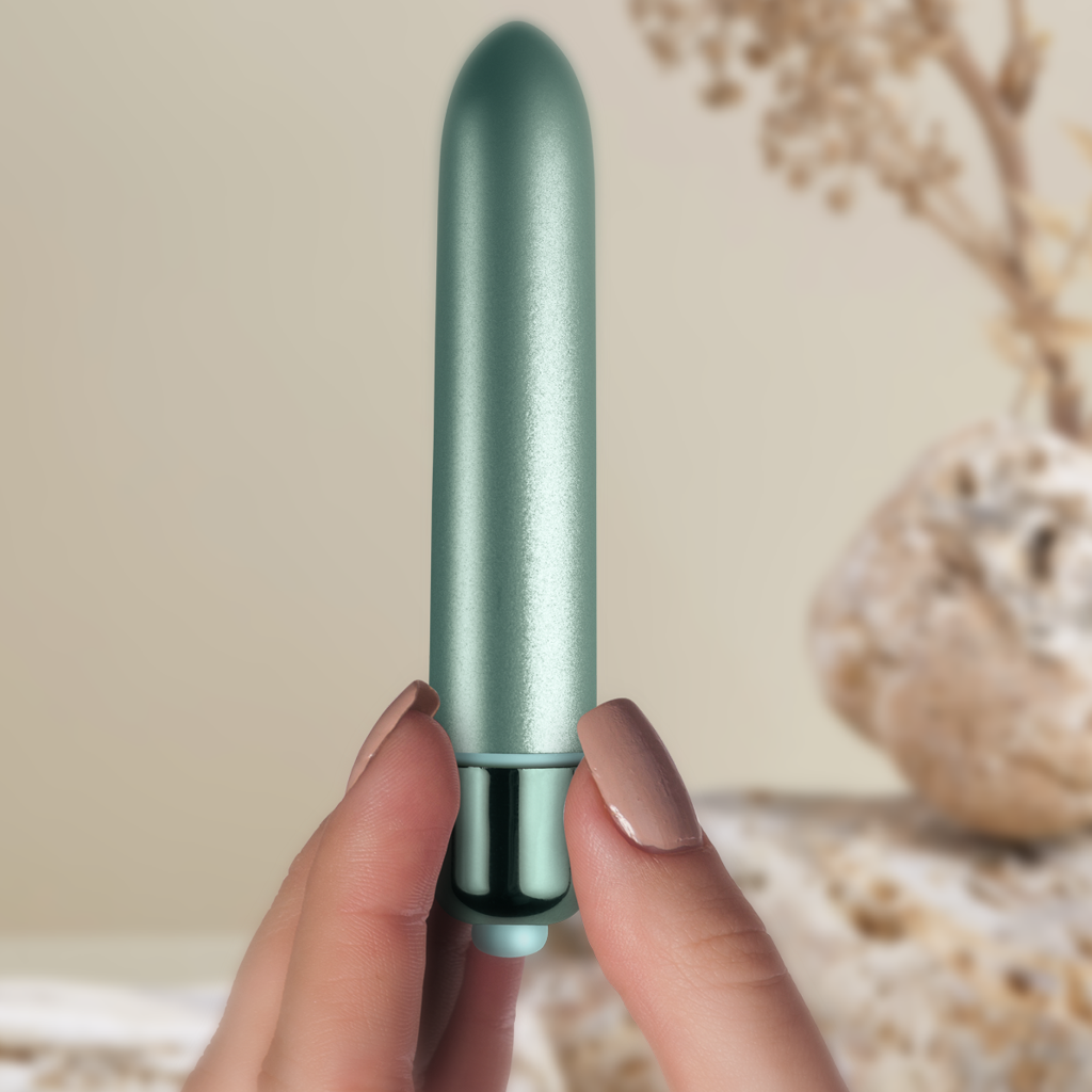 Teal bullet vibrator with glossy base, held between fingers