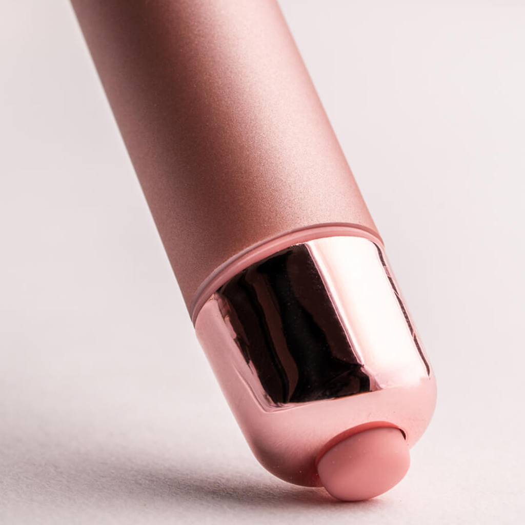 Rose gold bullet vibrator tip detail with dark window and rounded end cap