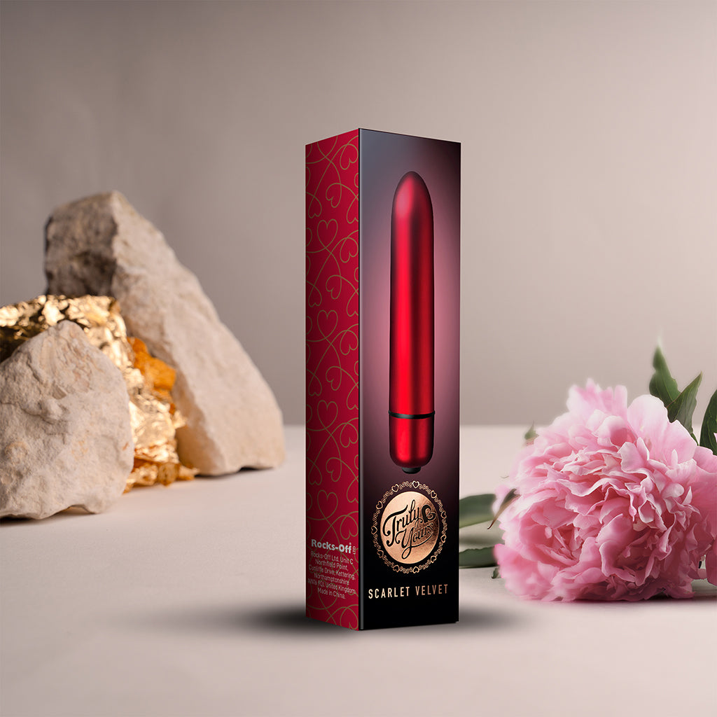 Scarlet Velvet bullet vibrator Packaging. Box shot of product shown with a flower and rock for scale. 