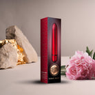 Scarlet Velvet bullet vibrator Packaging. Box shot of product shown with a flower and rock for scale. 