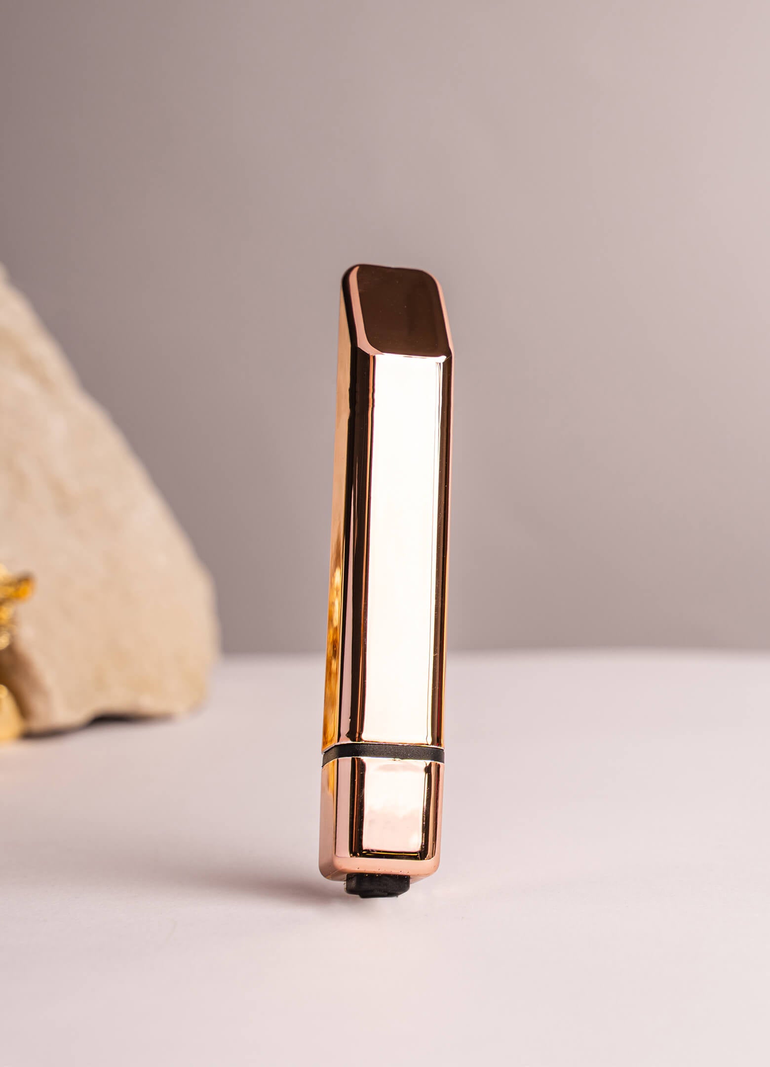 Small glossy gold vibrator designed like a lipstick.