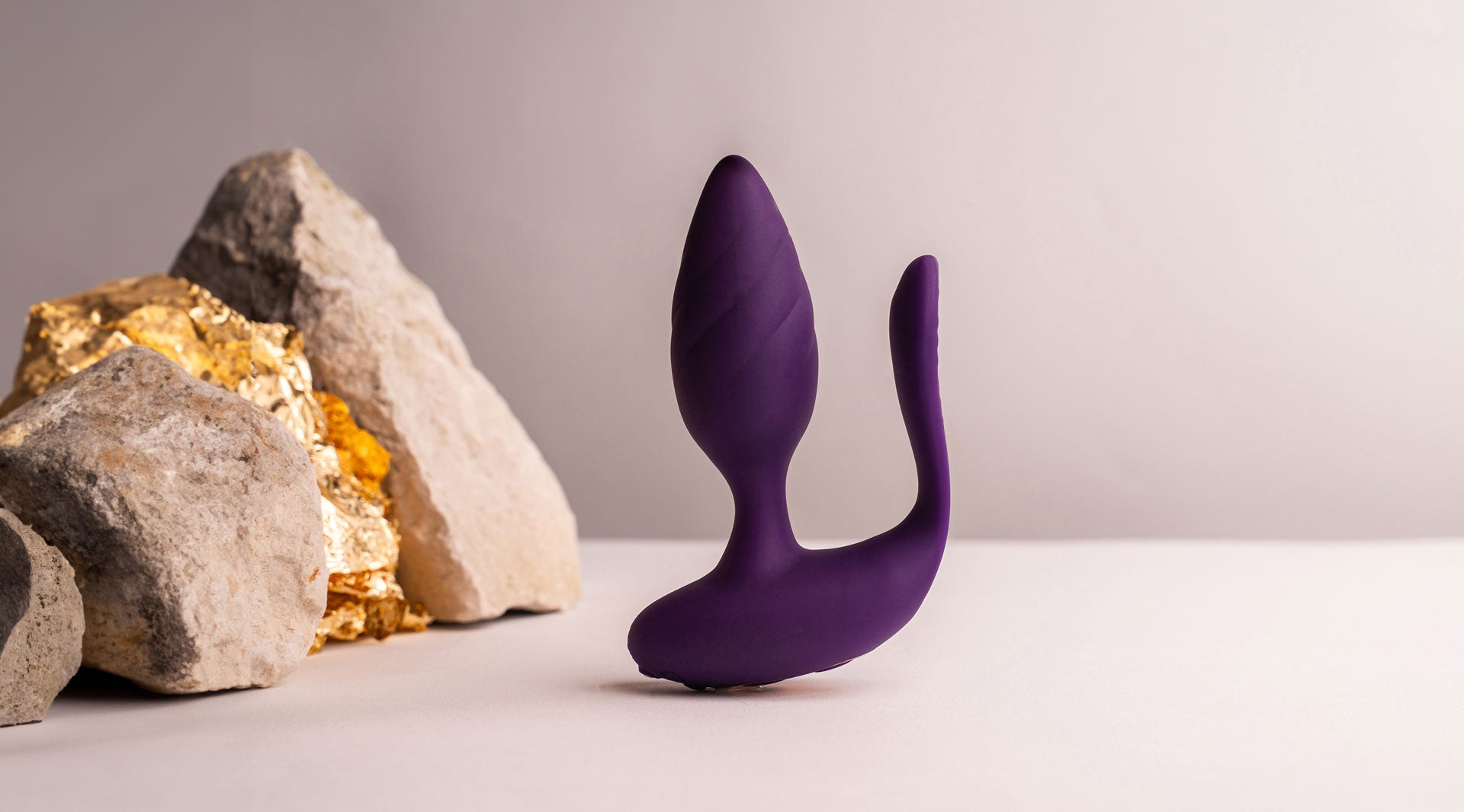 Purple silicone butt plug with an insertable vaginal tail.