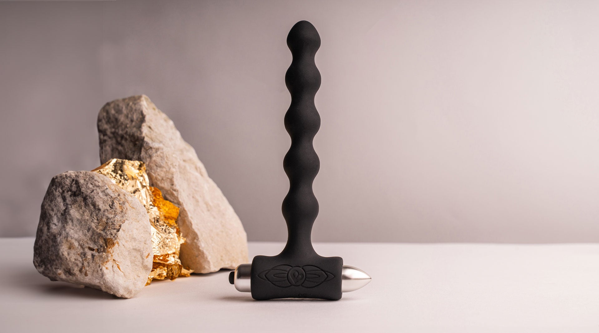 Beaded silicone butt plug in black housing a removable bullet vibrator.
