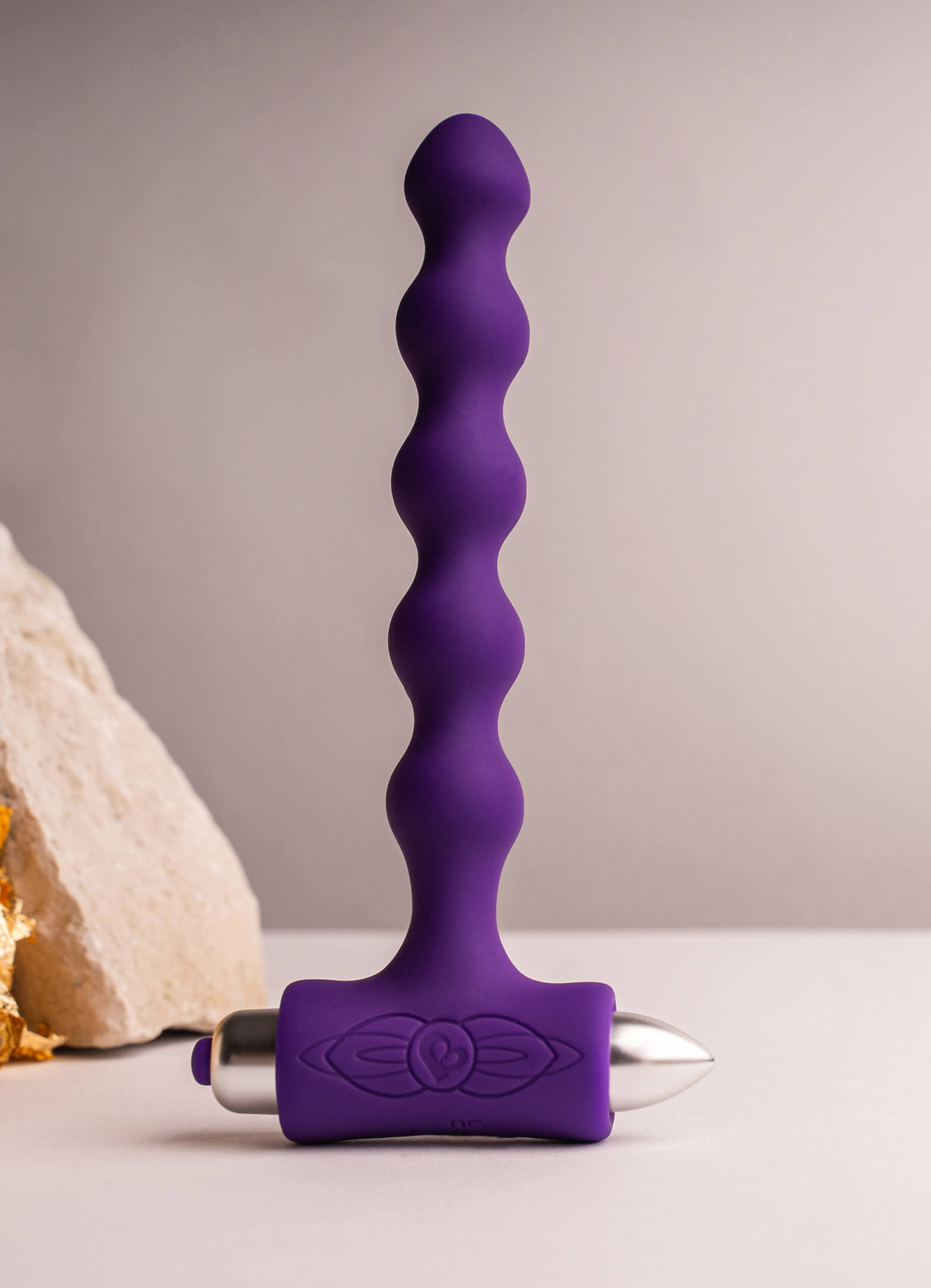 Beaded silicone butt plug in purple housing a removable bullet vibrator.